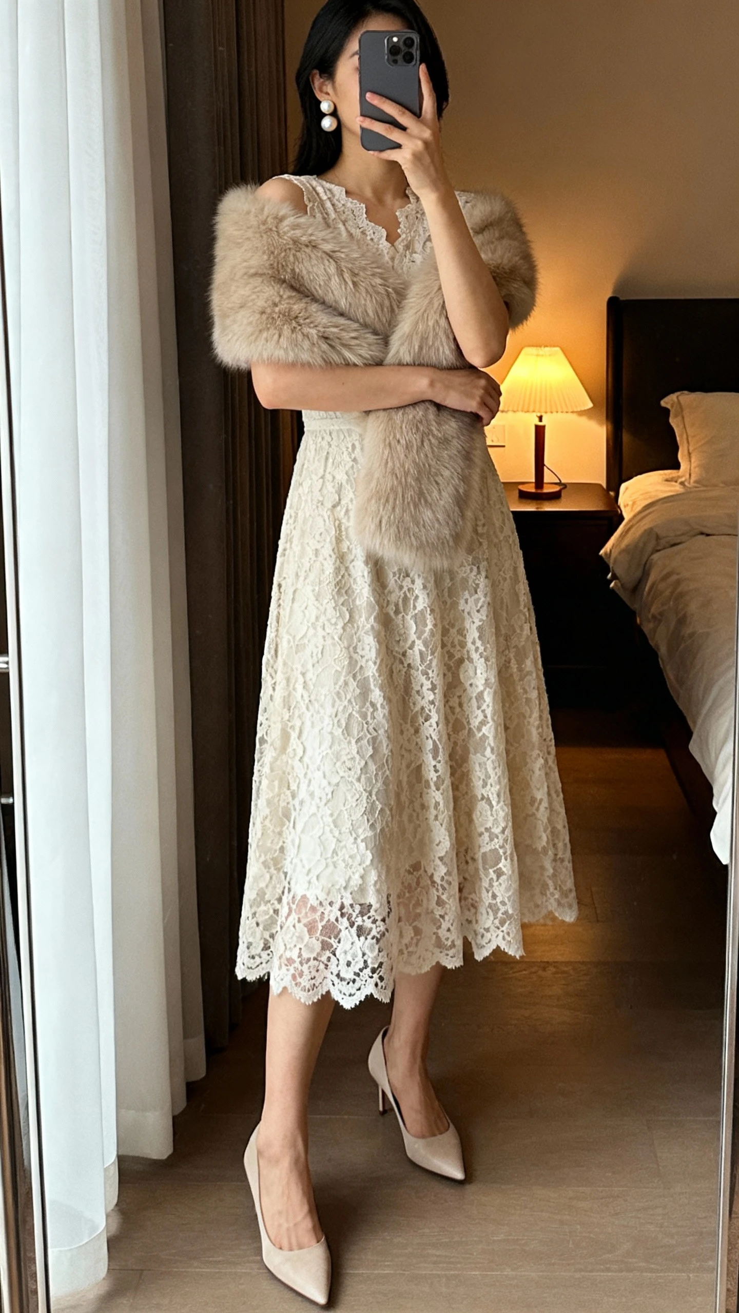 iPhone mirror selfie of a woman wearing a lace midi dress with a faux-fur shoulder wrap, pearl earrings and classic pumps, face not visible, bedroom full-length mirror, soft evening lamp light, natural iPhone photo quality.
